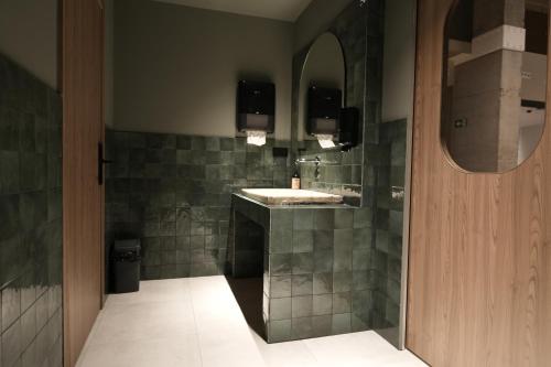 CASA ROMA Hostel Boutique في تاراغونا: حمام مزود بحوض ومِرآة