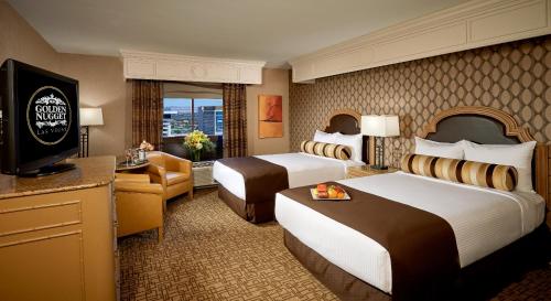 a hotel room with two beds and a television at Golden Nugget Hotel & Casino Las Vegas in Las Vegas