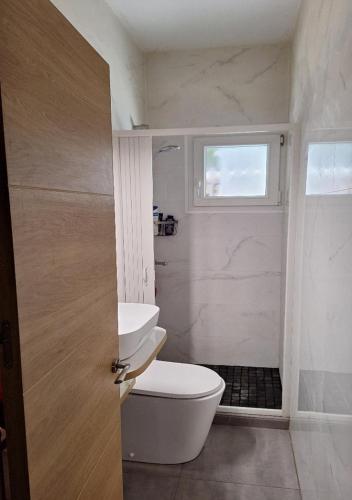 a bathroom with a toilet and a sink and a window at Chalet antiguo reformado "El Mirador" in Hoyo de Pinares