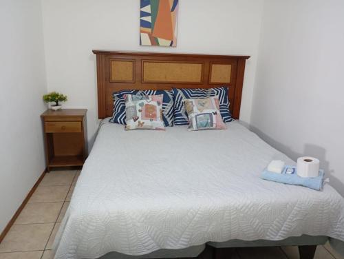 a bedroom with a bed with a wooden headboard and pillows at Alojamiento Puente Alto in Santiago