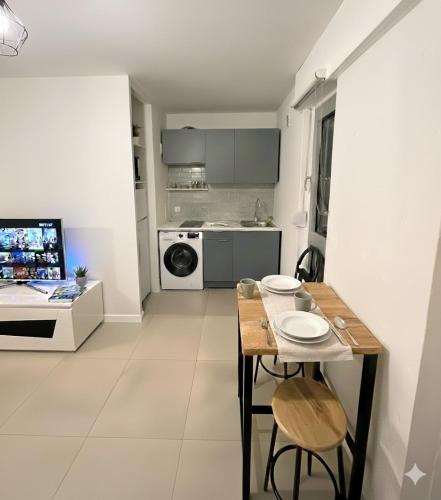 a kitchen and living room with a table and chairs at Cozy studio avec balcon aux portes de Genève in Ambilly