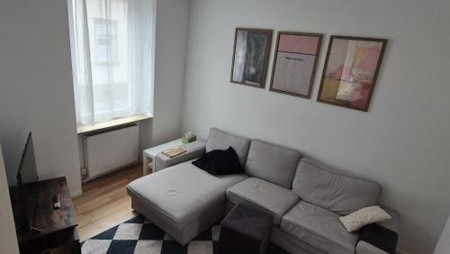un soggiorno con divano e alcune immagini sul muro di Central City Apartment Mozart a Kaiserslautern