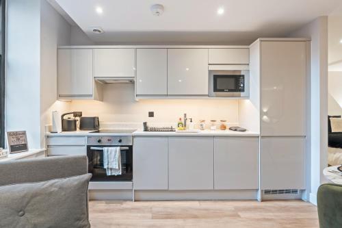 Una cocina con gabinetes blancos y una estufa. en Studio Seven - Leeds City Centre, en Central Station