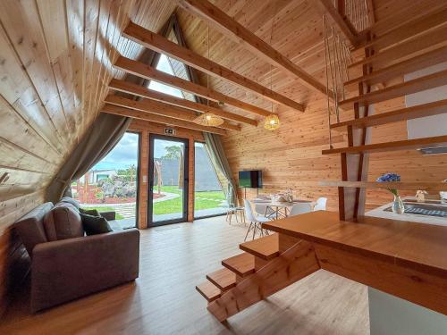 a living room with wooden walls and a wooden ceiling at Quinta do Ícaro - Nature Living in Fonte Bastardo