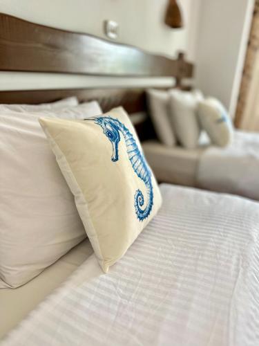 a white bed with a blue and white pillow on it at Daniela Diving Resort Dahab in Dahab