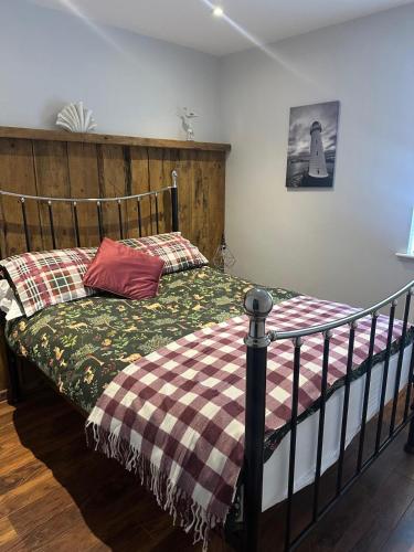 a bedroom with a bed with a wooden headboard at 2 hunters lane Donaghadee in Donaghadee