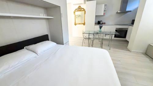 una camera da letto con un letto bianco e un tavolo di Zambianchi Studio - Sostify a Bergamo