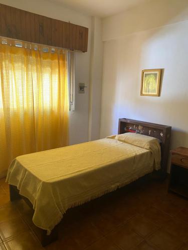 a bedroom with a bed with a yellow bedspread at Santa Tere in Santa Teresita