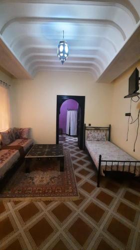 Una sala de estar con dos camas y un sofá en Riad Des Artistes, en Oulad Akkou