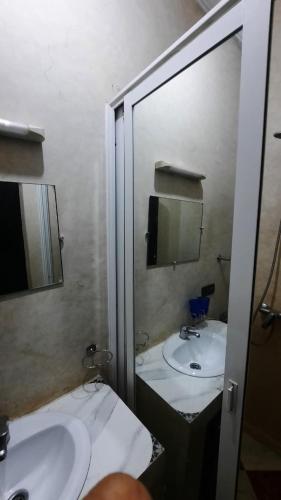 un baño con dos lavabos y un espejo en Riad Des Artistes, en Oulad Akkou