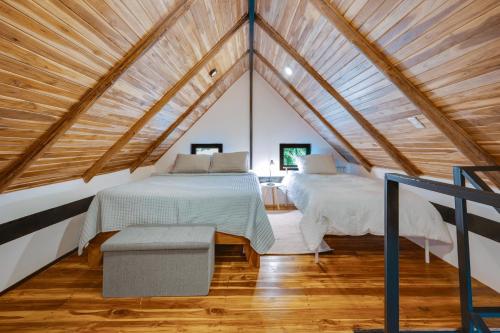 two beds in a room with a roof at 5 Lofts En La Paraiso in Playa Grande