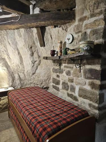 a bedroom with a bed in a stone wall at La Casetta nella Roccia in Torricella Peligna