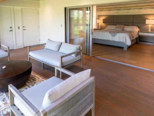 ein Schlafzimmer mit einem Bett, einer Couch und einem Tisch in der Unterkunft Bentley Beach House in Sanibel