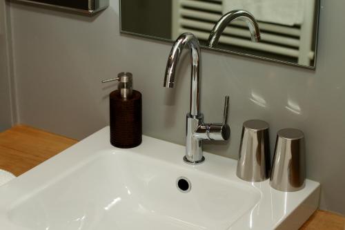 lavabo con grifo y 2 tazas en Strandhotel Margaretha, en St. Wolfgang