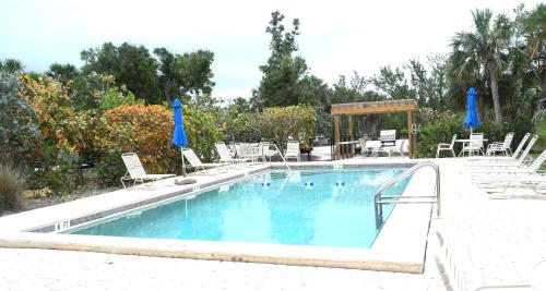einen großen Pool mit Stühlen und einem Pavillon in der Unterkunft Bentley Beach House in Sanibel