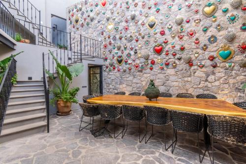 Casa Studio San Miguel de Allende في سان ميغيل دي الليندي: جدار حجري مع طاولة وكراسي خشبية
