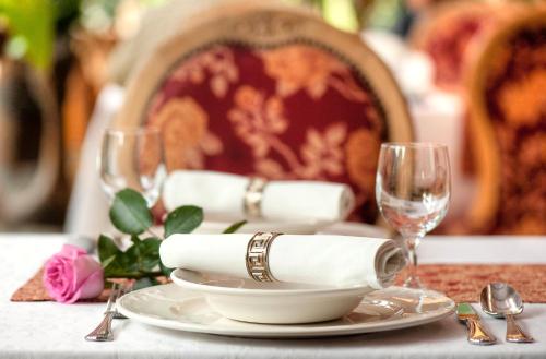 a table with a plate and two wine glasses at Hotel Zameczek in Książ Wielki