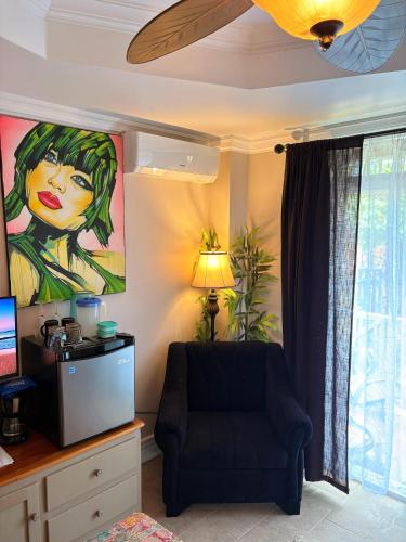 Caye Caulker Boutique Guesthouse 4 في كاي كولكر: غرفة معيشة بها كرسي ودهان على الحائط
