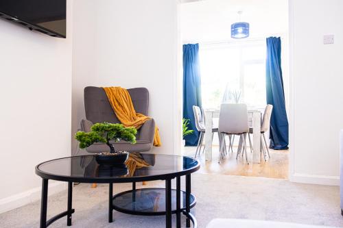 a living room with a table and a chair at Modern 3 Bedroom Home, 6 beds, Free Parking, 500MBS, Netflix, Near Coventry City Centre & Hospital, Contractors, Families, Apple Air Play in Coventry