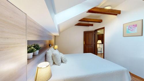 ein Schlafzimmer mit einem weißen Bett und einer Holzwand in der Unterkunft Hrabovo Helena 19 in Ružomberok