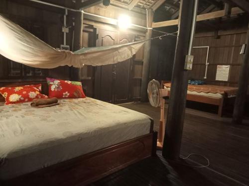 Sconvolt Homestay في كراتي: غرفة نوم بسرير مع ناموسية