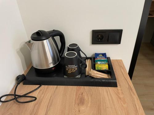 a tray with a coffee pot and two mugs on it at Farmer`s Hotel in Pereyaslav
