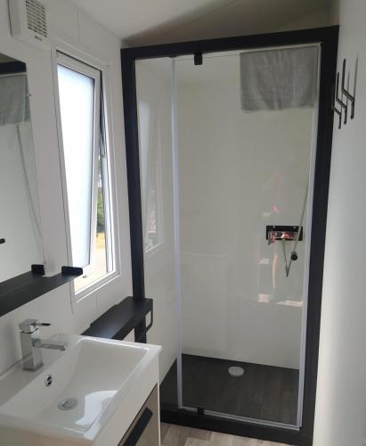 a bathroom with a white sink and a window at Mobile Homes by KelAir at Camping Sylvamar in Labenne