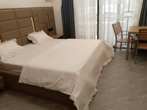 una camera da letto con un letto grande, un tavolo e delle sedie di JAMOS House a Kigali