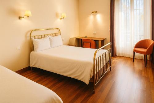 a hotel room with a bed and a chair at Hôtel Terminus in Cahors