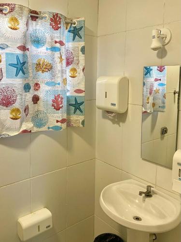 a bathroom with a sink and a mirror at Cosmopolitans Hostel in Ubatuba