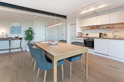 a kitchen and dining room with a wooden table and chairs at Gollings am See Gingko-Suite in Bosau