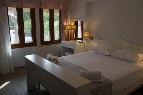 a bedroom with a large white bed and windows at Nafsika in Ioannina