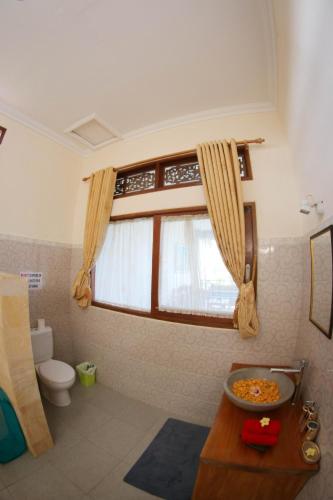 a bathroom with a toilet and a window at Villa Casa Lokke in Ubud