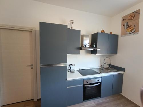 Una cocina con un refrigerador azul y un fregadero. en Sidera Dafni, en Dervio