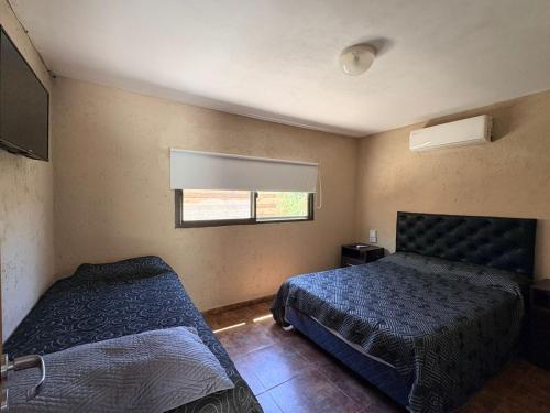 una camera da letto con due letti e una finestra di Los Frutales a Villa Carlos Paz