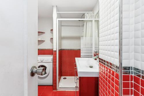 een rood-witte badkamer met een wasmachine bij Francysara Holiday in Benalmádena