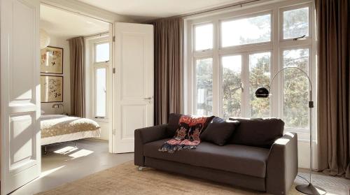 a living room with a couch in front of a window at Top Floor Apartment Vondelpark in Amsterdam