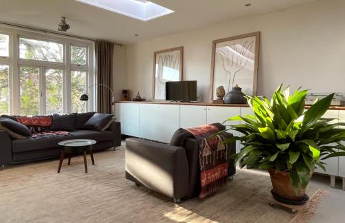 a living room with a couch and a tv at Top Floor Apartment Vondelpark in Amsterdam