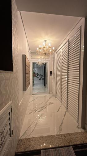 a hallway with a chandelier and a room with a fireplace at Ap 503 Ed Brisa do sol em Piratuba in Piratuba