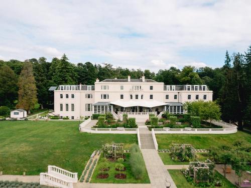 an aerial view of a large white house with a garden at Coworth Park - Dorchester Collection in Ascot