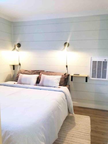 a bedroom with a large white bed with two lamps at Camp Carter Tiny House in Mathias