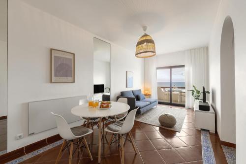 een woonkamer met een tafel en een bank bij Pérola do Mar in Foz do Arelho