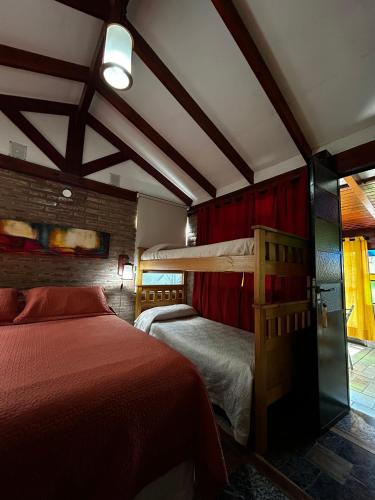 PurinkiWasi - La casa de todos في لوس ريترز: غرفة نوم بسريرين وسقف مع عوارض