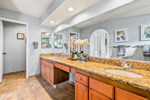 een badkamer met twee wastafels en een grote spiegel bij Grand Champions 160 in Wailea