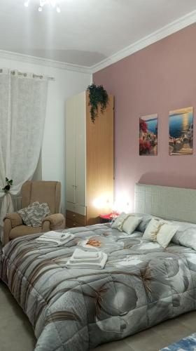een slaapkamer met een groot bed en een stoel bij La ninfa B&B in Salerno