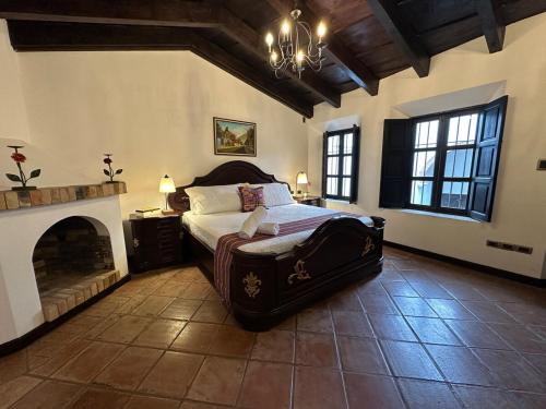 a large bedroom with a bed and a fireplace at Lovely house in Antigua Guatemala for 7 guests in Cataltzul