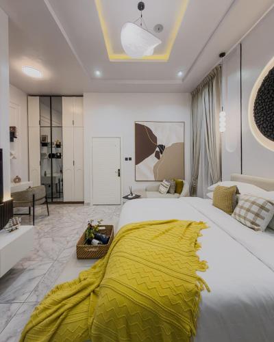 a bedroom with a large bed with a yellow blanket on it at Modern 3BR Smart Villa near Lekki Conservation with Inverter PS5, Hot Tub and Gym in Ibeju