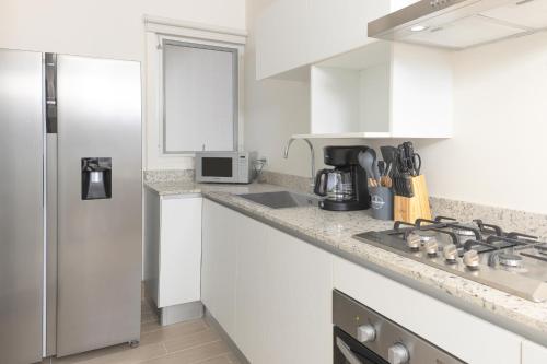 a white kitchen with a sink and a refrigerator at Brisas del Mar by Playa Caracol Resorts in Punta Chame