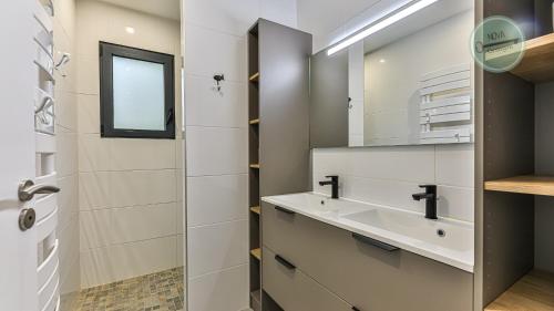 een badkamer met een wastafel en een spiegel bij Villa Boreal in Saint-Gilles-Croix-de-Vie