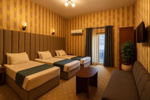 a hotel room with two beds and a couch at Veda hotel in Cairo